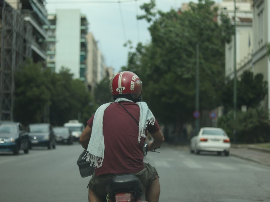 Motorcyclist on a city street, viewed from behind