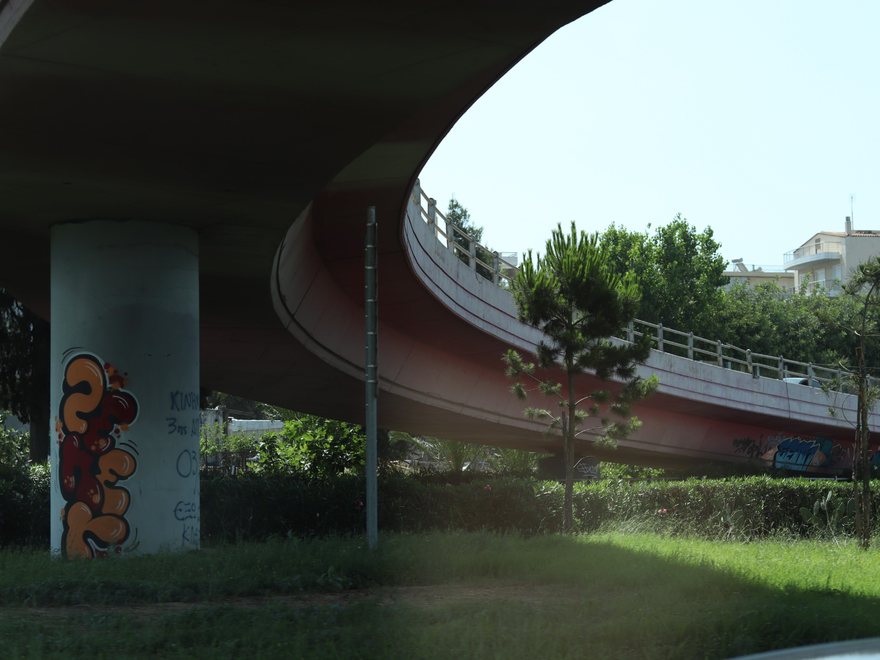 Curving flyover, concrete supports and vegetation