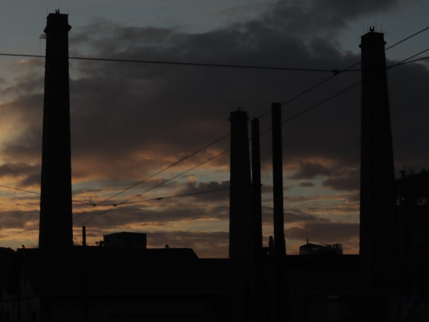 Industrial chimneys silhouetted at dusk